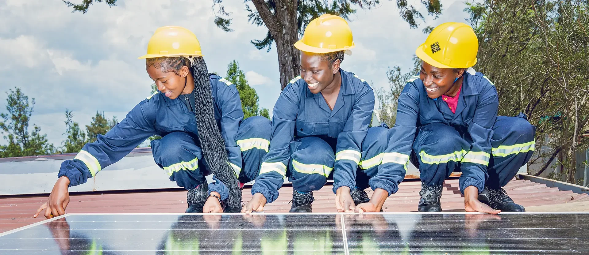 Trainees in safety gear aligning a rooftop solar panel during a WTS Foundation capacity building program in Kenya