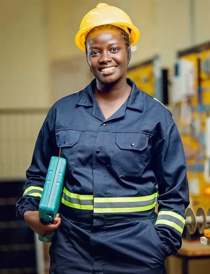 Student in safety gear holding a tool case in an e-mobility training lab during the E-mobility course in Kenya